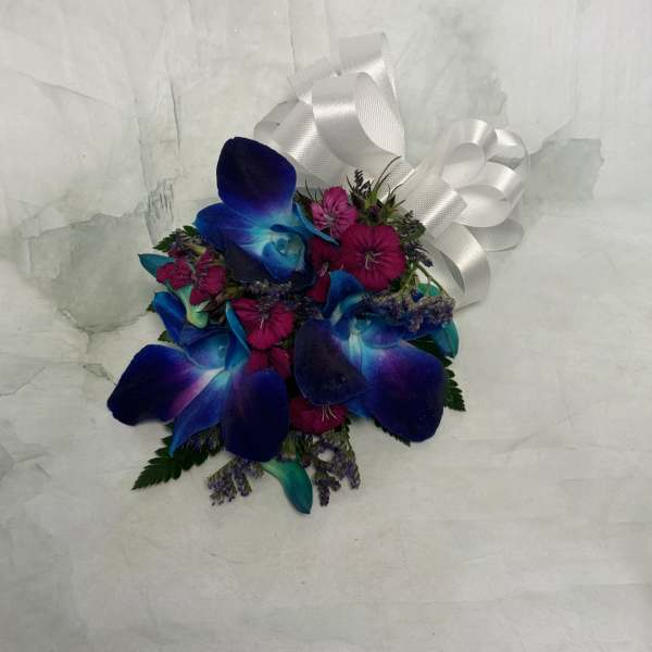Small bouquet of blue orchids and pink flowers with a white ribbon