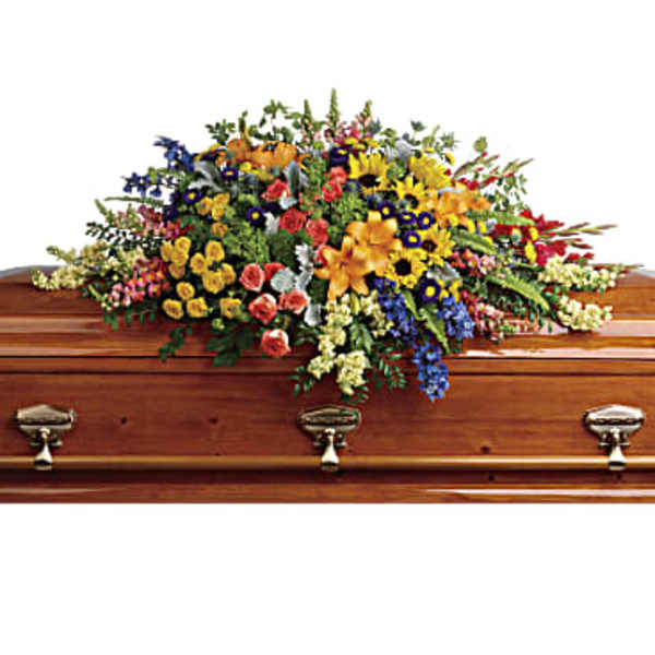 Colorful flower spray arranged on a wooden casket