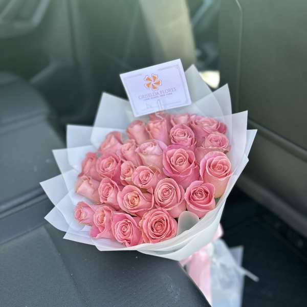 Bouquet of pink roses wrapped in white paper
