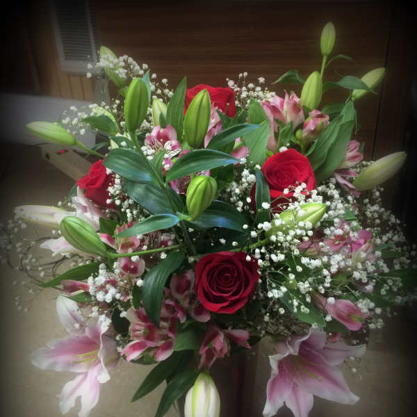 Bouquet of red roses, pink lilies, and white baby's breath