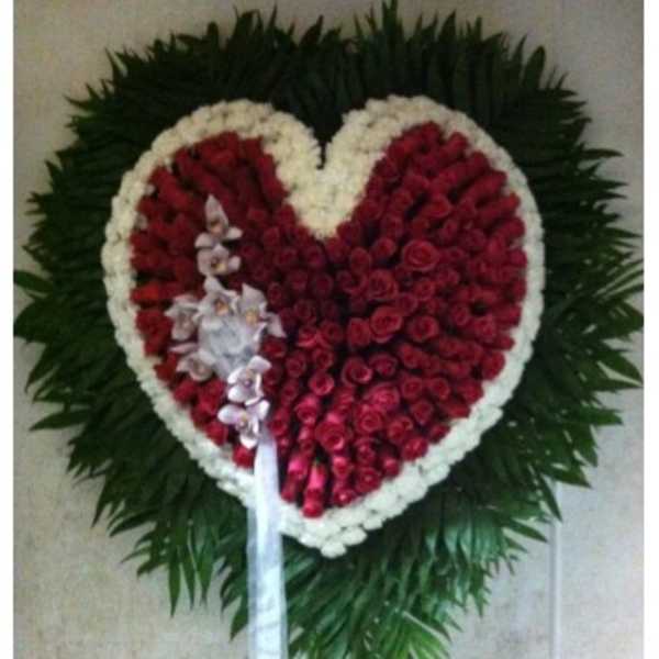 Heart-shaped red rose wreath with white border and ribbon