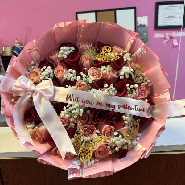 Bouquet of red and blush roses with a pink ribbon and Valentine message