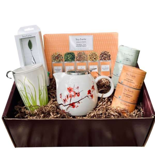 Tea gift basket with a floral teapot, mug, and assorted tea tins
