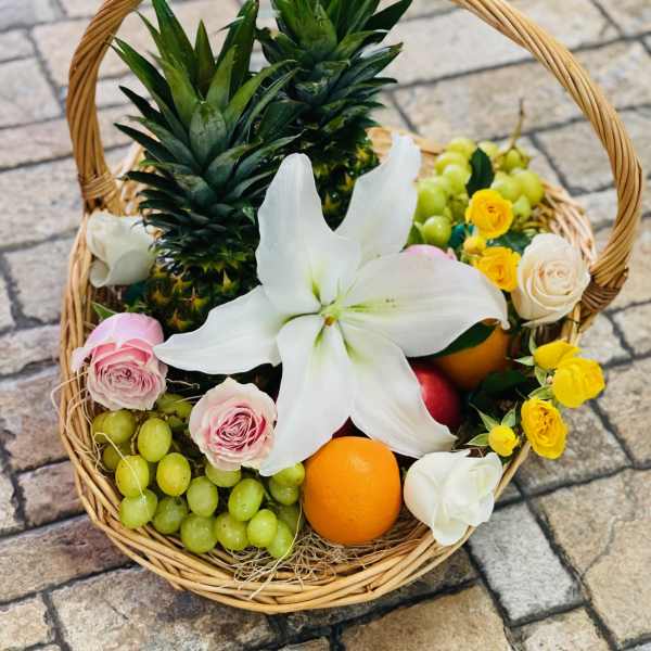 Fruit basket with flowers in a wicker handle basket
