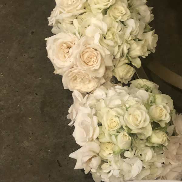 White rose and hydrangea floral garland on a dark surface