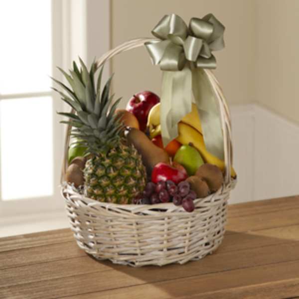 Wicker basket filled with assorted fruit and topped with a ribbon bow