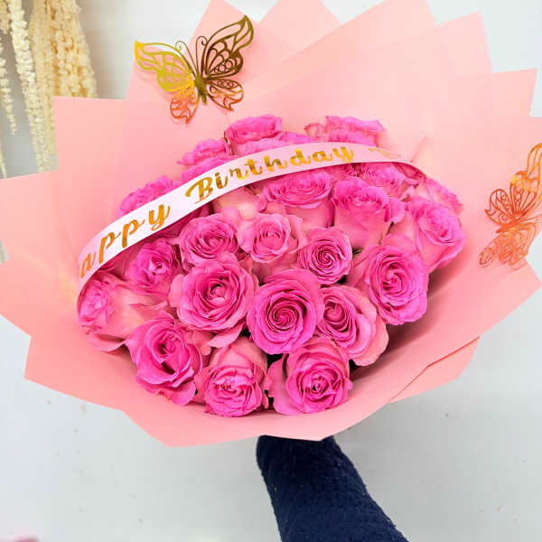 Pink rose bouquet with a birthday ribbon and butterfly decorations