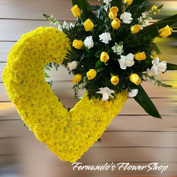 Large yellow chrysanthemum heart with a cluster of yellow and white roses on one side