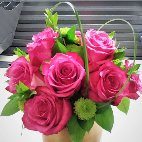 Pink rose bouquet in a gold box with green accents
