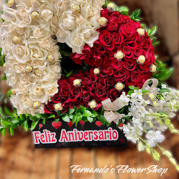 Heart-shaped arrangement of cream and red roses with chocolates and white orchids in an anniversary box