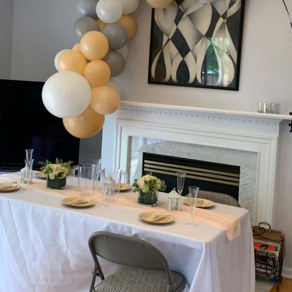Balloon garland in white, gray, and gold over a decorated table