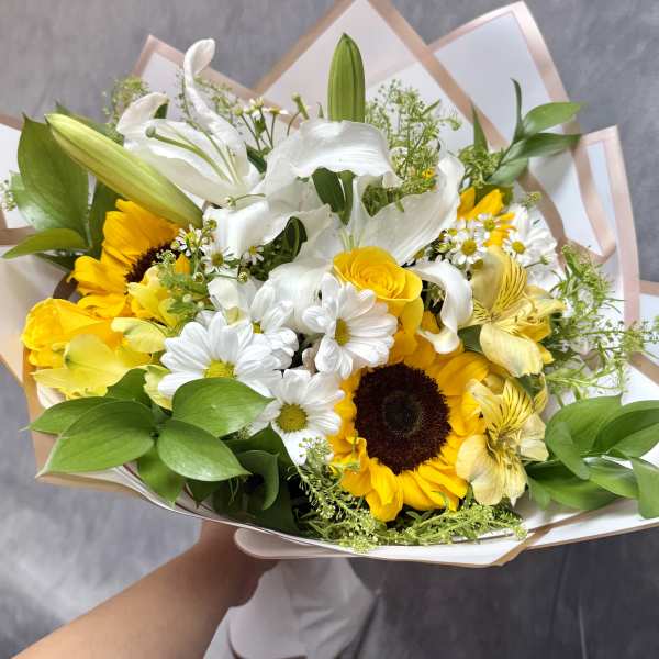 Bouquet of white lilies, sunflowers, and daisies with yellow blooms