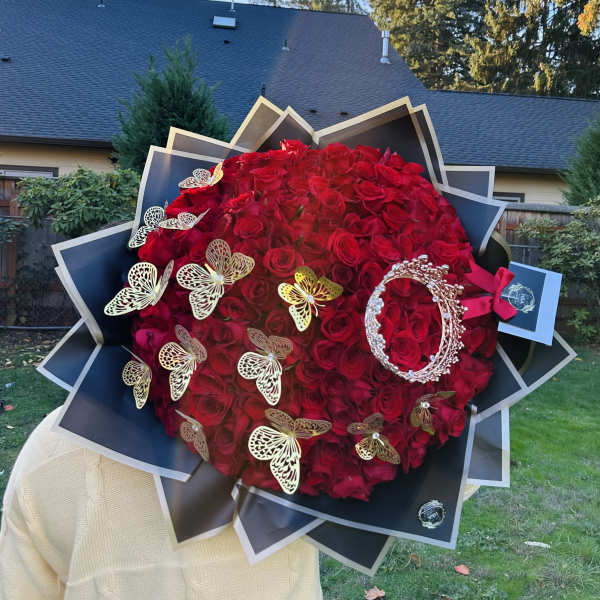 Large bouquet of red roses with butterfly decorations and black wrapping