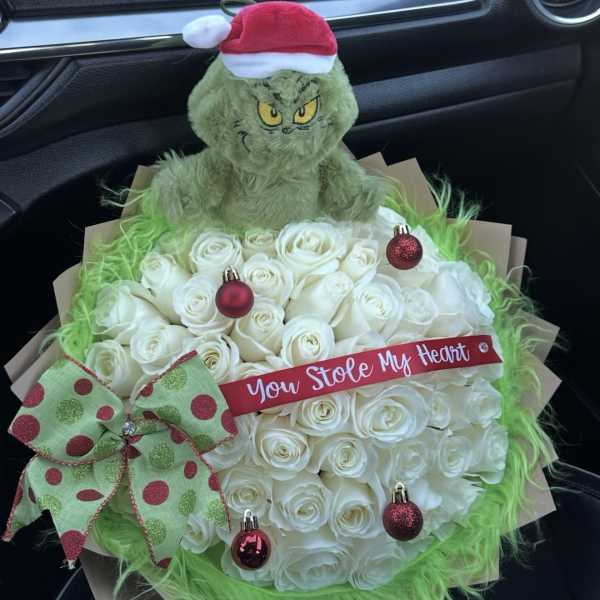 White rose bouquet with a Grinch plush and Christmas ornaments