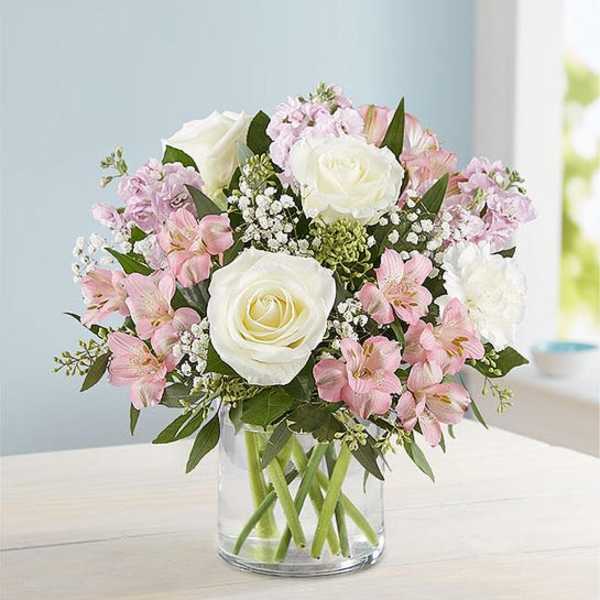 Pink and white bouquet of roses and alstroemeria in a clear glass vase