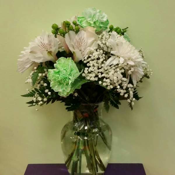 White and green bouquet in a clear glass vase