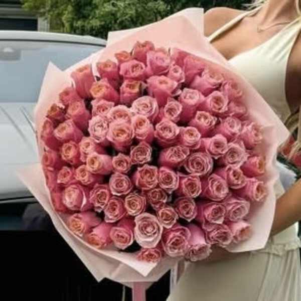 Large bouquet of pink roses wrapped in pale pink paper