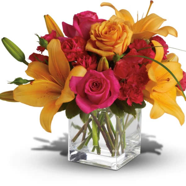 Pink roses and orange lilies in a clear glass vase