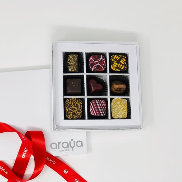 Box of assorted chocolates with a red ribbon and card