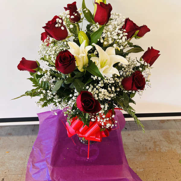 Bouquet of red roses and white lilies in a glass vase