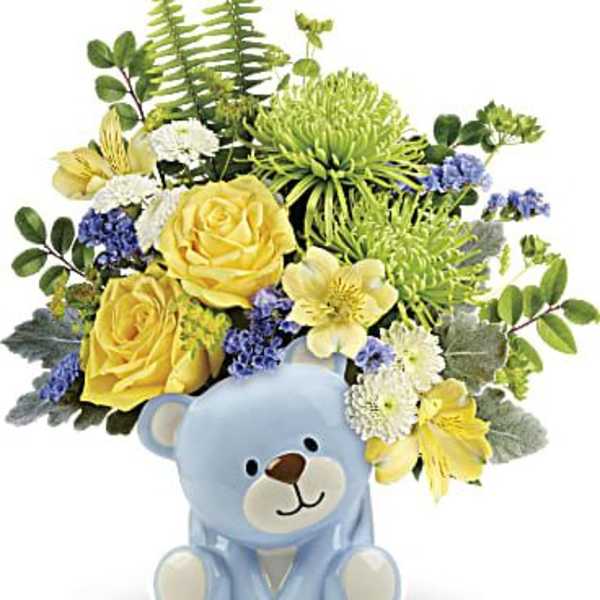 Yellow roses and mixed flowers in a blue teddy bear vase