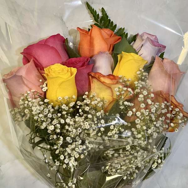 Bouquet of multicolored roses with baby's breath wrapped in clear plastic