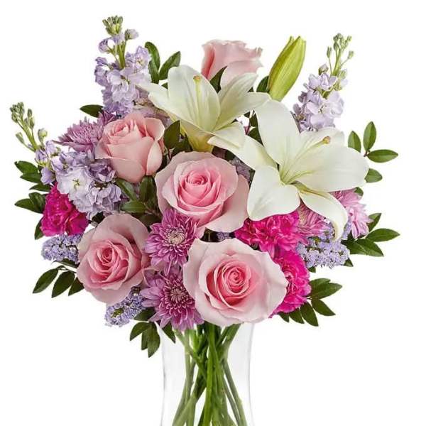 Pink roses and white lilies in a clear glass vase