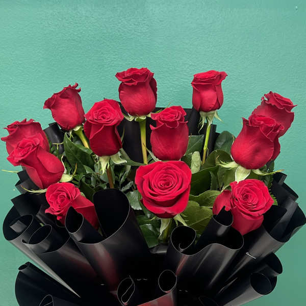 Bouquet of red roses wrapped in black paper with a red ribbon