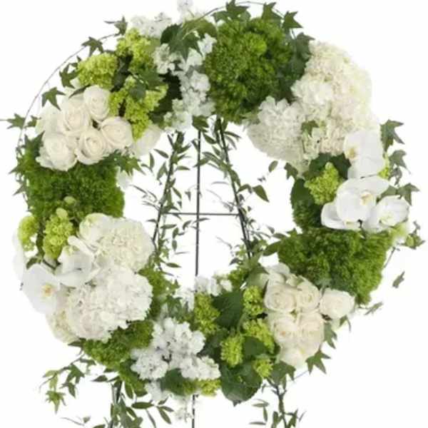 White and green floral wreath on a stand