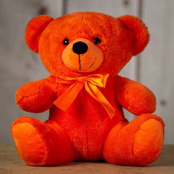 Orange plush teddy bear with a satin bow