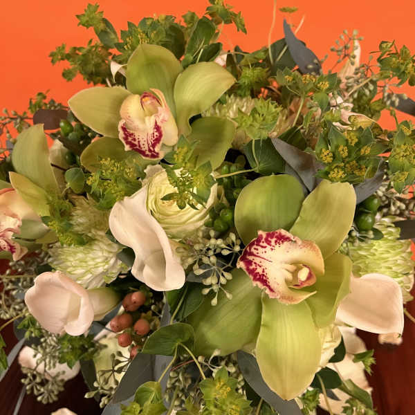 Bouquet with green cymbidium orchids, white calla lilies, and pale roses