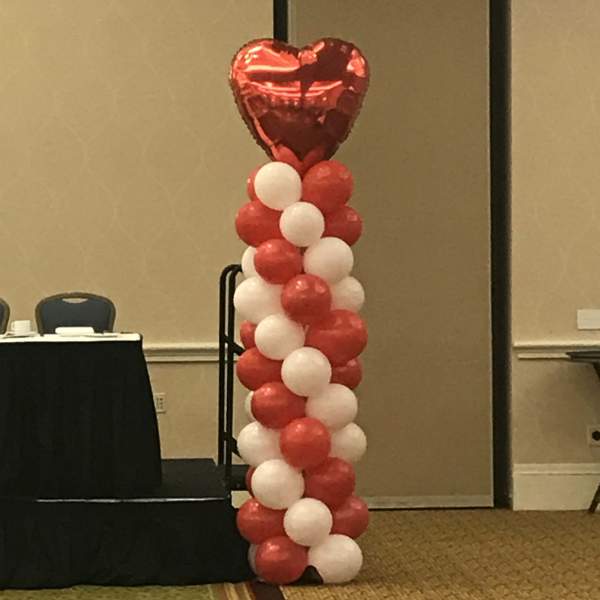 Red and white balloon column topped with a heart balloon