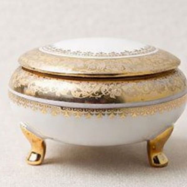 Decorative white and gold lidded trinket box on small feet