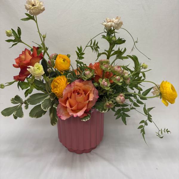 Mixed bouquet of roses and ranunculus in a pink vase