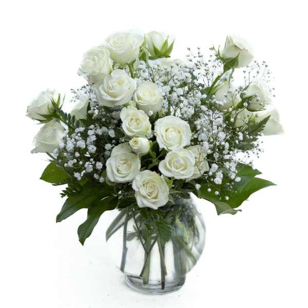 White roses and baby's breath in a clear glass vase