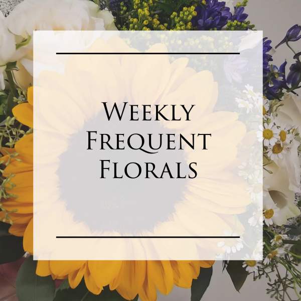 Mixed floral arrangement with a large sunflower and white and purple blooms
