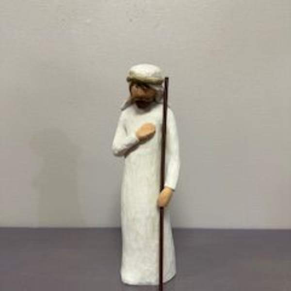 Small figurine of a man in a white robe holding a staff