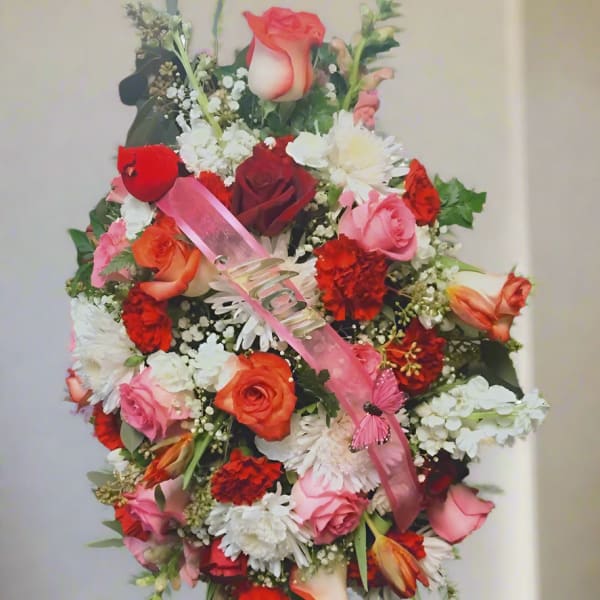 Large mixed floral standing spray with pink ribbon and butterfly accent