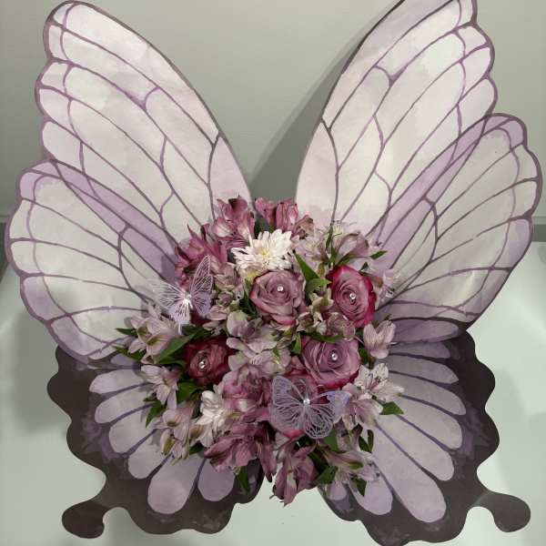 Butterfly-shaped floral arrangement with pink roses and alstroemeria