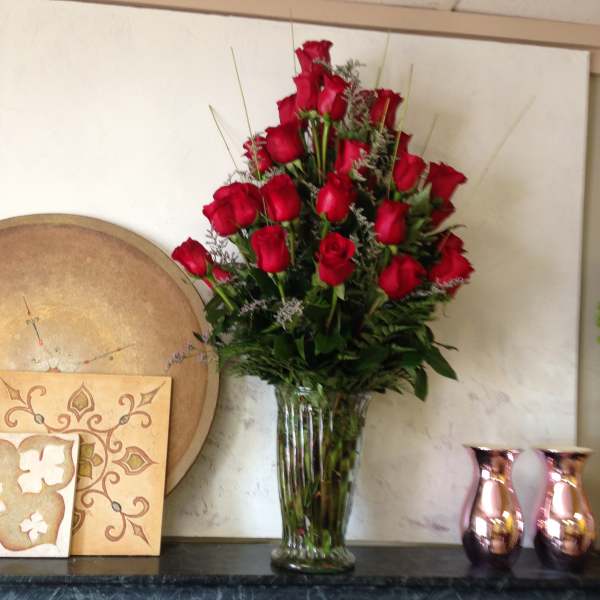 Tall bouquet of red roses in a clear glass vase
