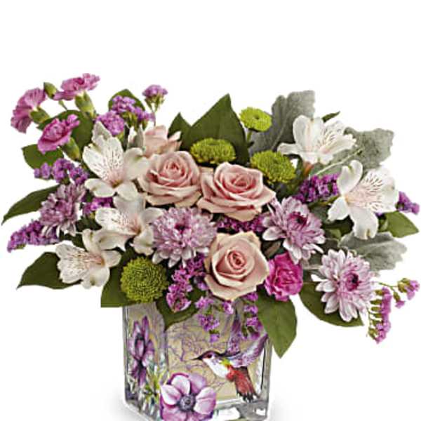 Pink roses and purple flowers arranged in a square glass vase
