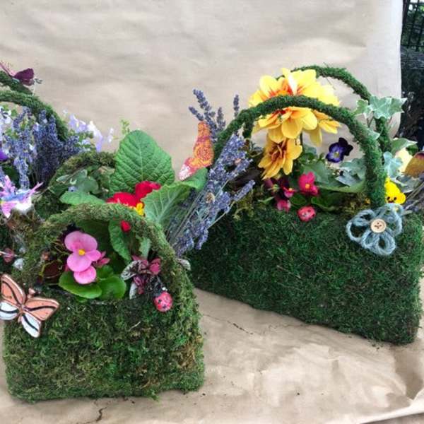 Three moss-covered baskets with colorful flowers and butterfly decorations