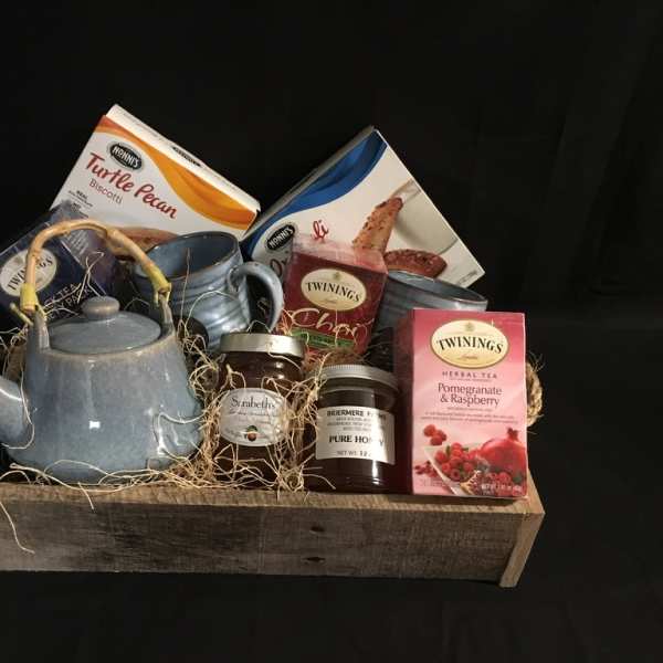 Gift basket with tea, biscotti, honey, jam, and a blue teapot