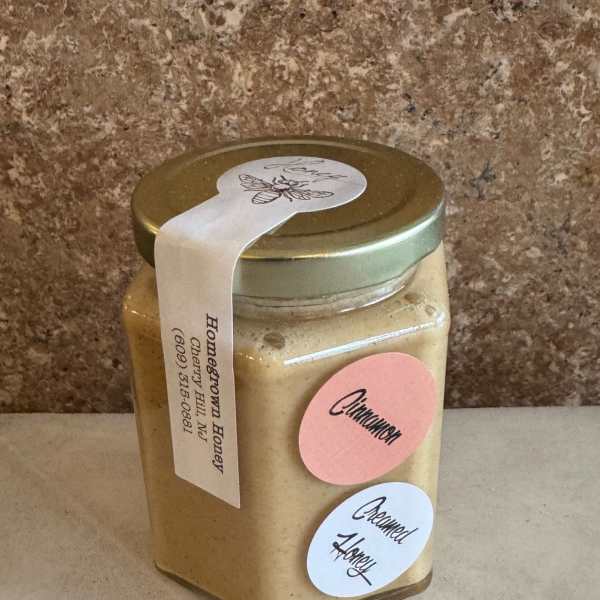 Jar of homemade honey with cinnamon and creamed honey labels