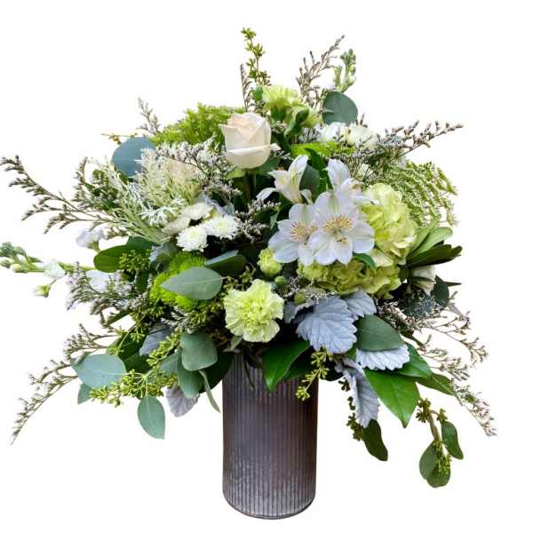 White and green floral arrangement in a tall ribbed vase