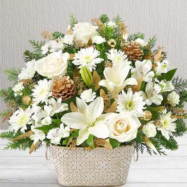 White flowers arranged in a decorative basket with pinecones and greenery