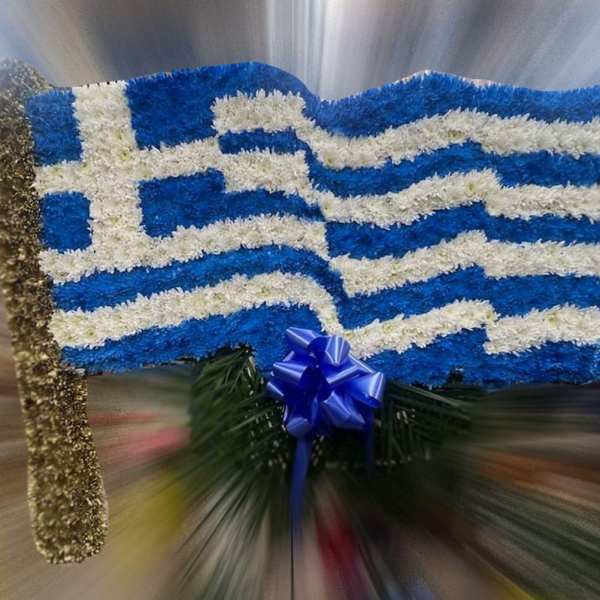 Floral arrangement shaped like the Greek flag with blue and white flowers and a blue ribbon bow