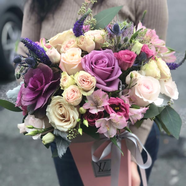 Hand-tied bouquet of pink, cream, and purple roses with alstroemeria