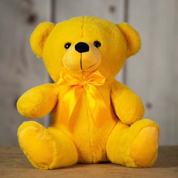 Yellow teddy bear with a satin bow