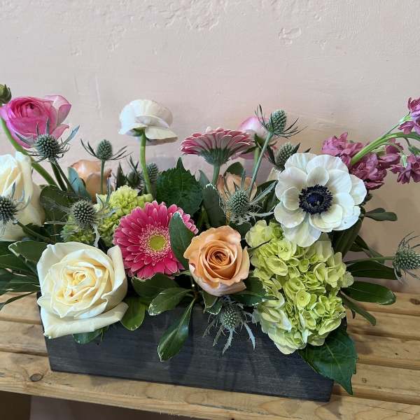 Mixed flower arrangement in a rectangular black container